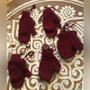 Mini red crimson knitted gloves.